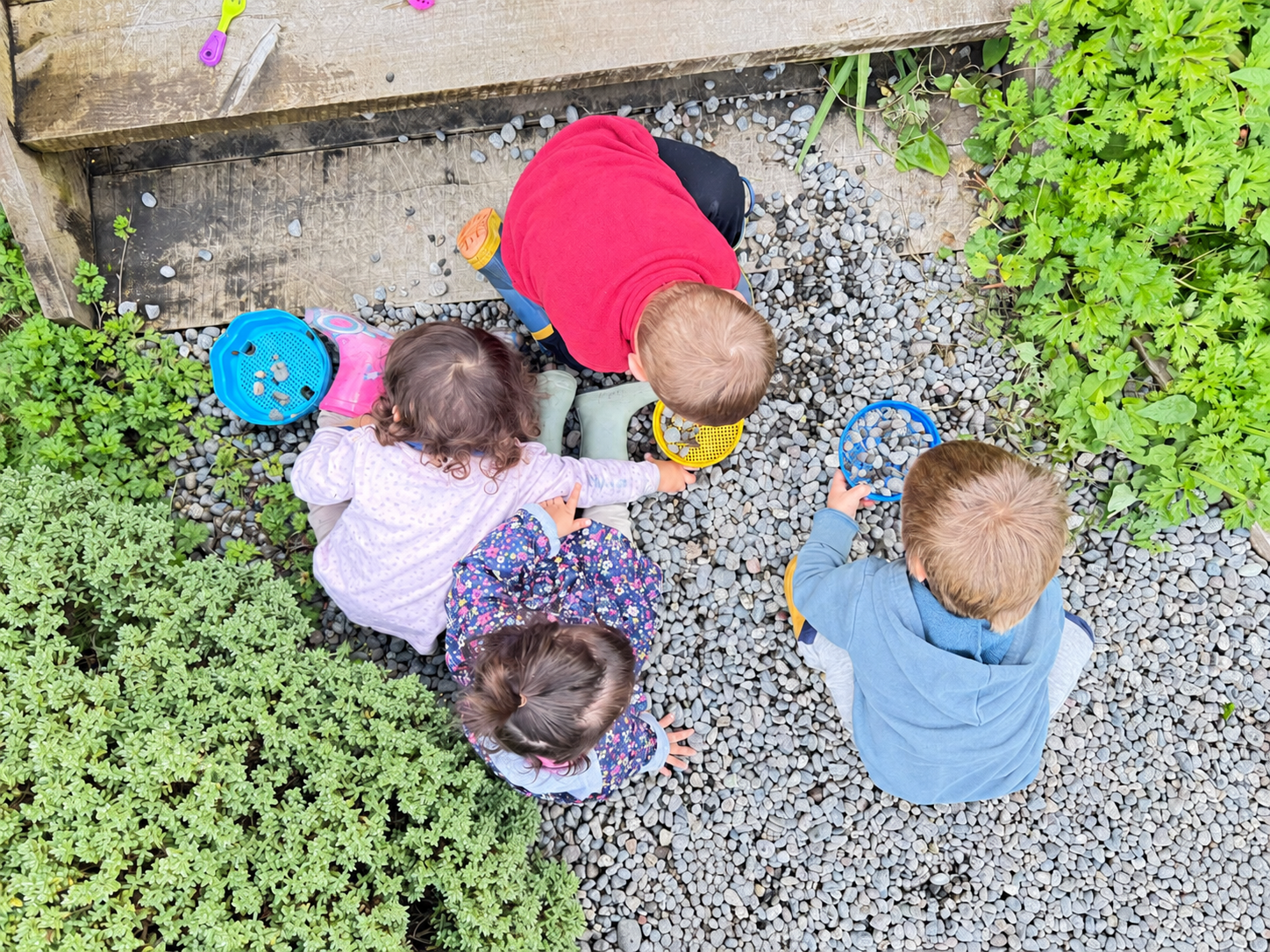 Niños y niñas explorando materiales al aire libre